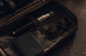 A disposable starter kit packed in a carry-on bag next to a passport and sunglasses.