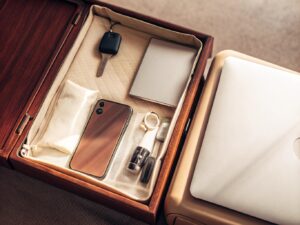 A tray at airport security showing a laptop, phone, keys, and a disposable vape in its original packaging.